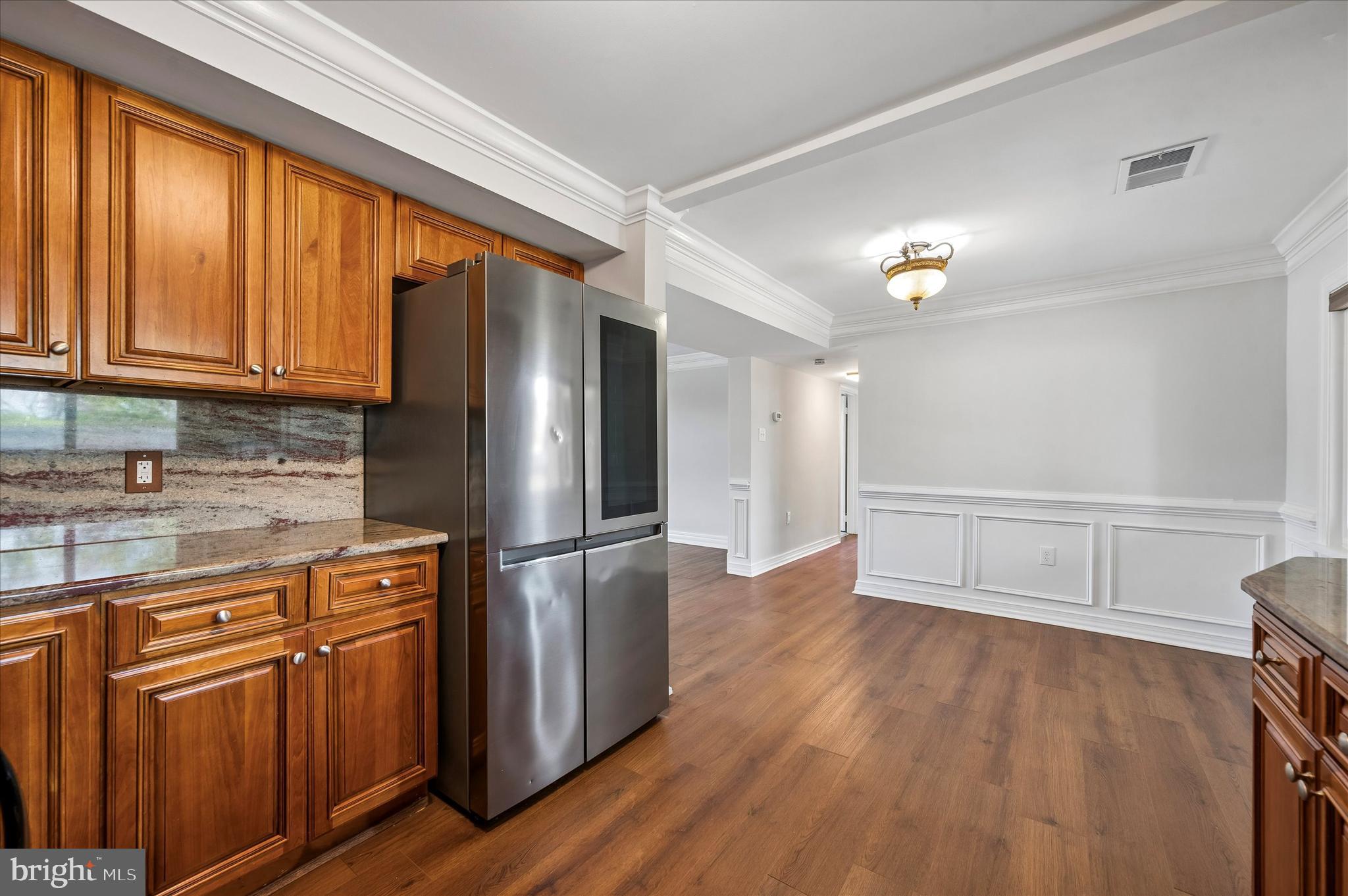 2154 Sproul Road Broomall, PA 19008 - Photo 13 of 25 a kitchen with stainless steel appliances granite countertop a refrigerator a sink dishwasher and wooden cabinets with wooden floor