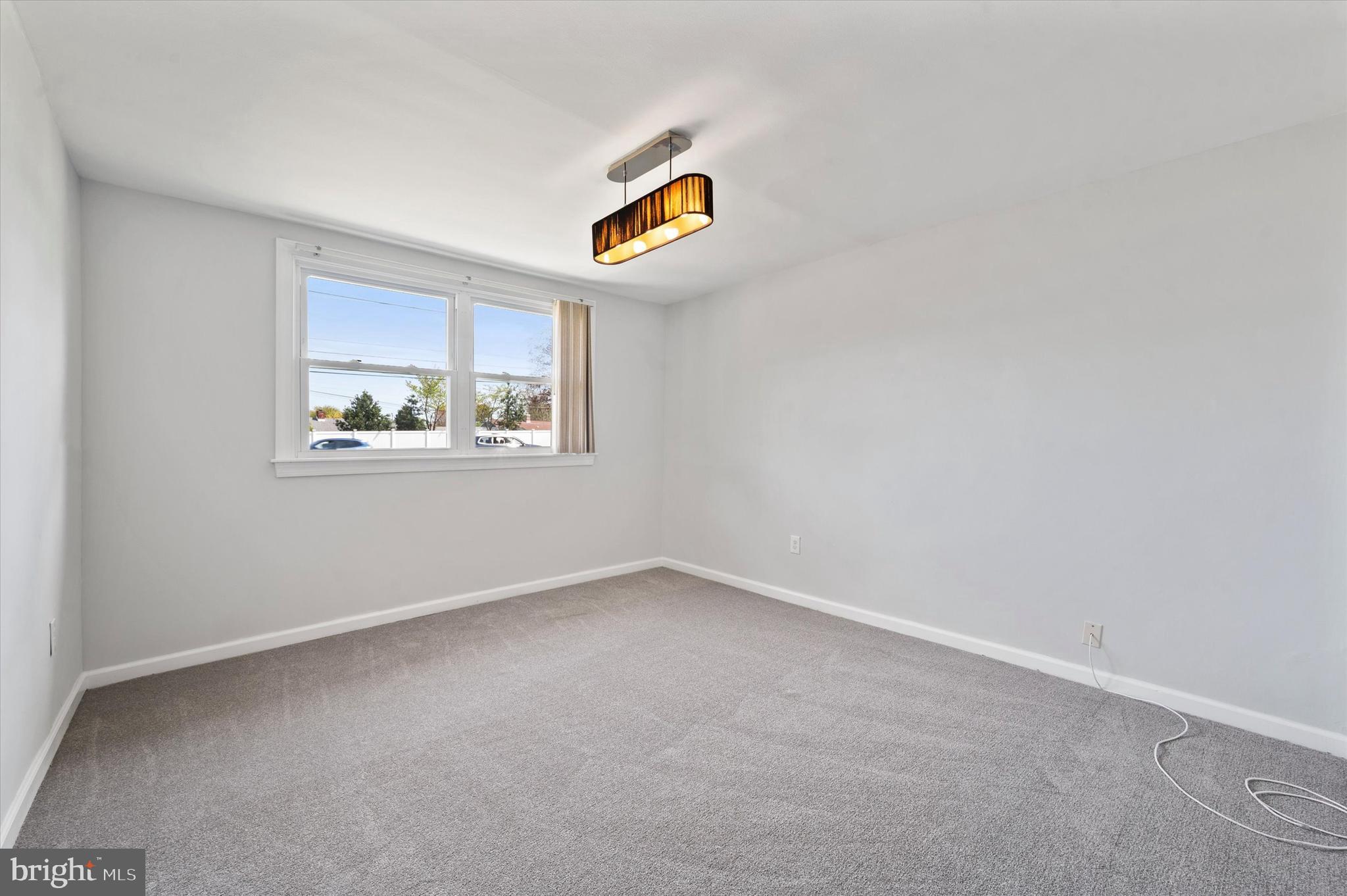 2154 Sproul Road Broomall, PA 19008 - Photo 21 of 25 an empty room with a window and a ceiling fan
