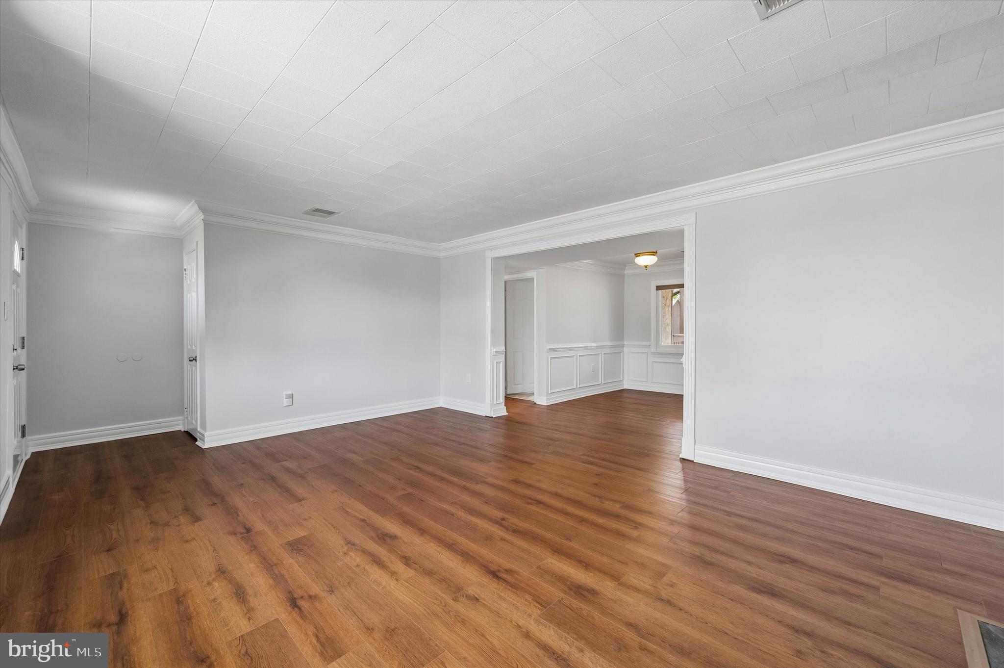 2154 Sproul Road Broomall, PA 19008 - Photo 5 of 25 a view of an empty room with wooden floor and a window