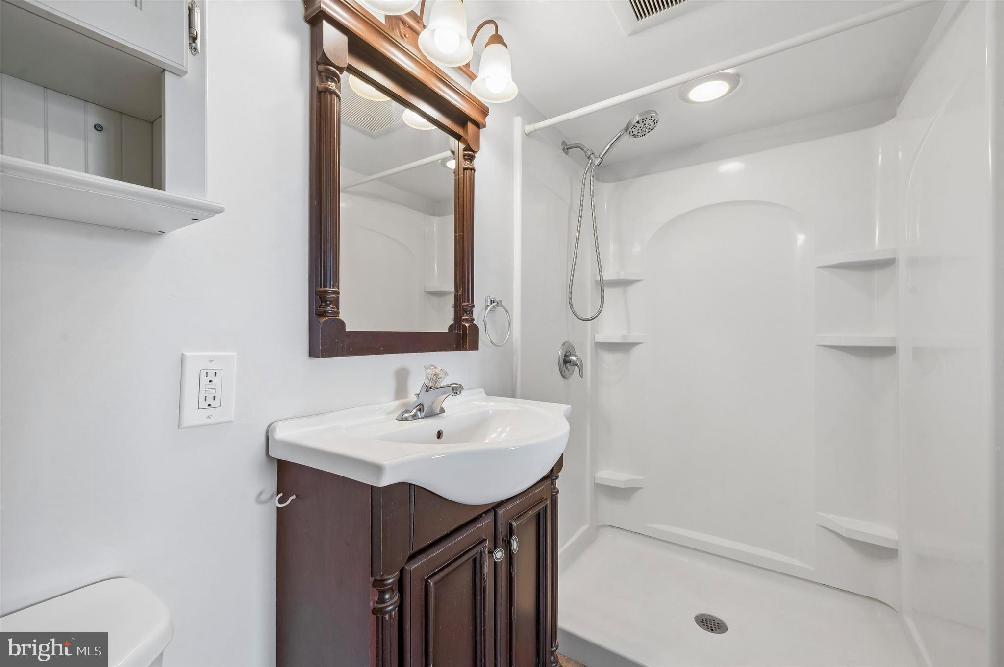 2154 Sproul Road Broomall, PA 19008 - Photo 8 of 25 a bathroom with a sink a mirror and a shower