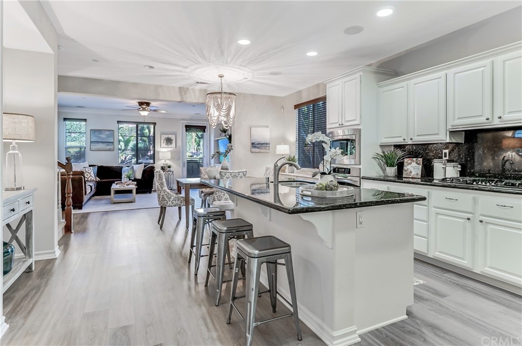 20 Paseo Canos San Clemente, CA 92673 - Photo 13 of 71 a kitchen with stainless steel appliances granite countertop a stove top oven a sink a dining table and chairs with wooden floor