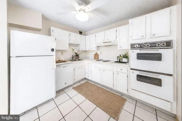 a kitchen with white cabinets and white appliances