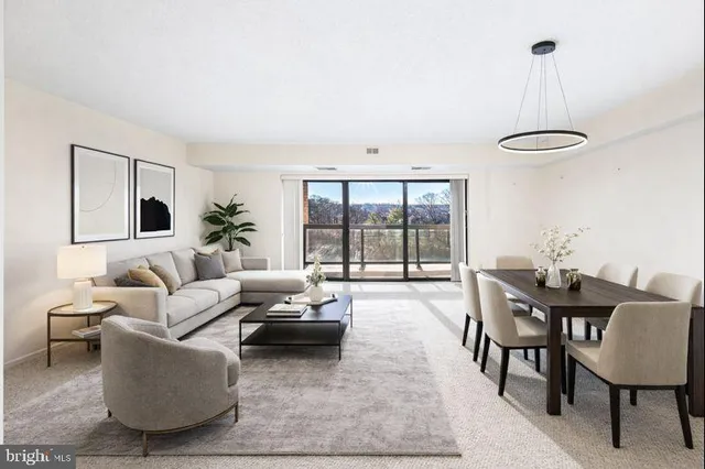 a living room with furniture a floor to ceiling window and a table