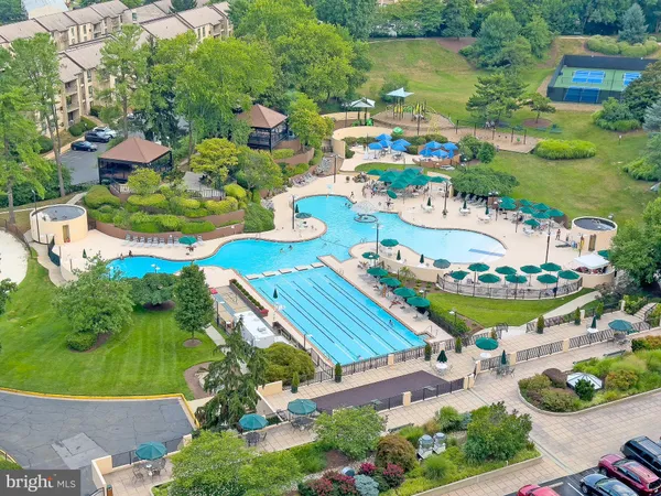 a view of an empty room with wooden floor and windows