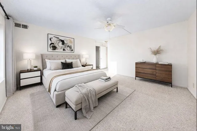 a bedroom with bed and paintings on the wall