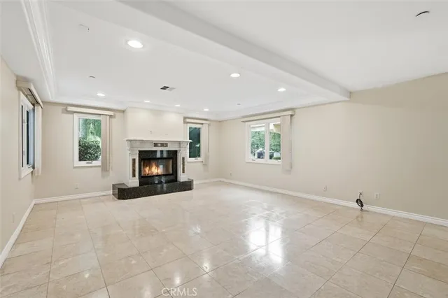 an empty room with windows and fireplace