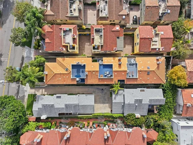 an aerial view of residential houses with outdoor space and parking