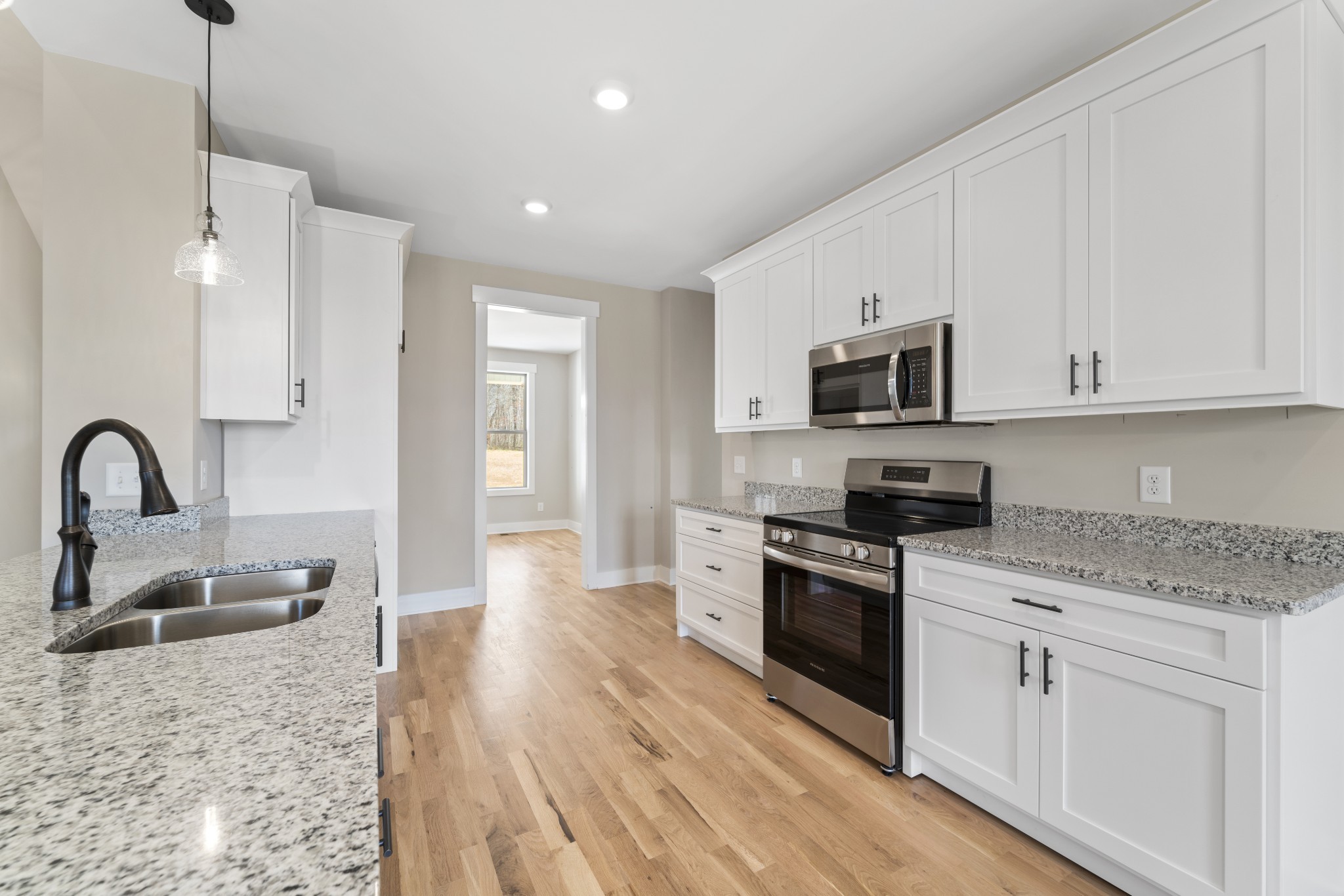 6120 Red River School Road Portland, TN 37148 - Photo 2 of 26 a kitchen with stainless steel appliances granite countertop a stove top oven a sink a refrigerator and white cabinets with wooden floor