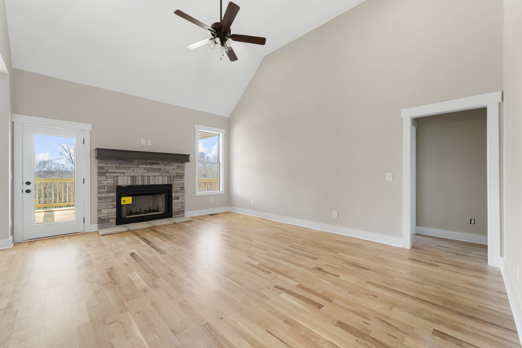 6120 Red River School Road Portland, TN 37148 - Photo 6 of 26 an empty room with wooden floor fireplace and windows