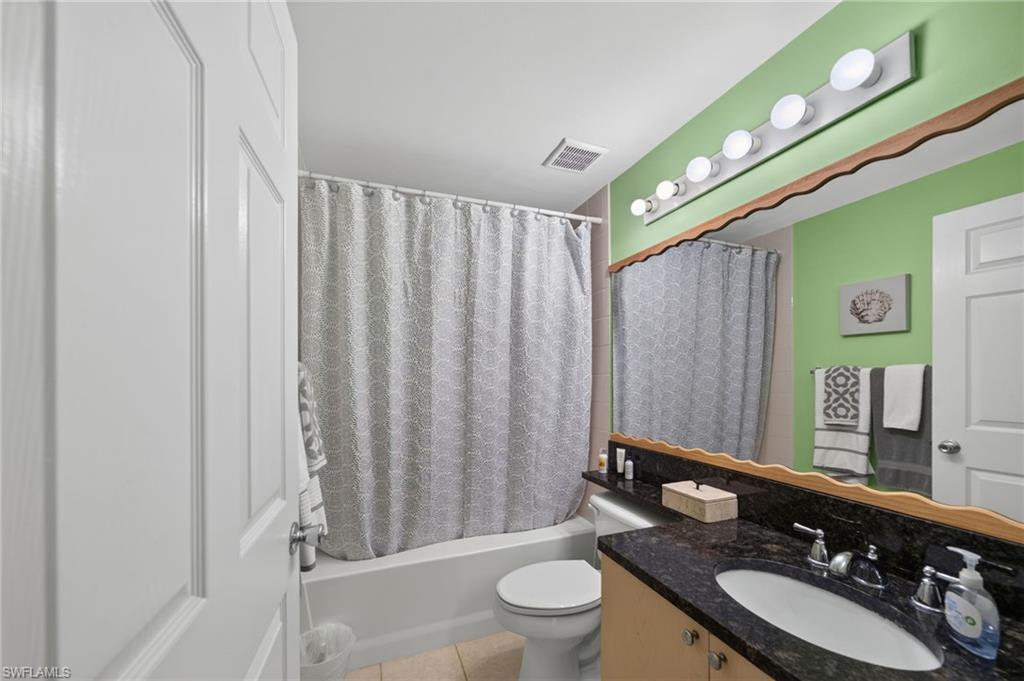1105 Reserve Court, Unit 206 Naples, FL 34105 - Photo 9 of 23 a bathroom with a sink a toilet a mirror and shower curtain