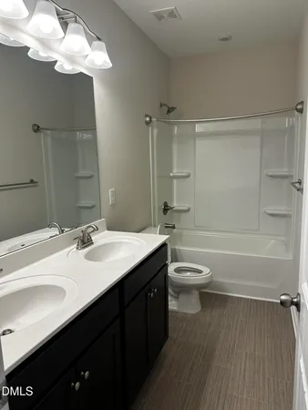 a bathroom with a granite countertop toilet sink and mirror