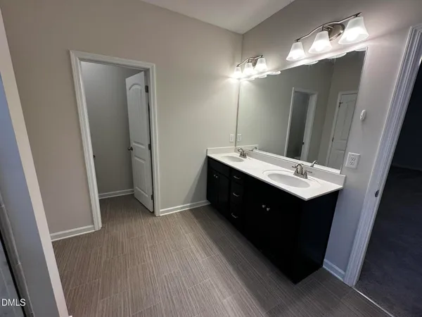 a bathroom with a double vanity sink and mirror