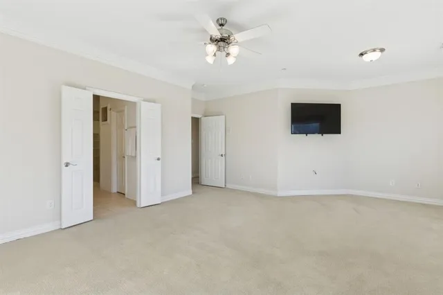an empty room with windows and a ceiling fan