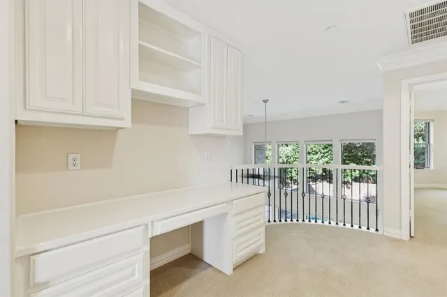 a hallway with white cabinets and wooden floor