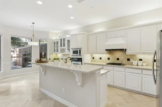 a large kitchen with kitchen island a sink stainless steel appliances and cabinets
