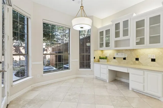 a large white kitchen with granite countertop a sink and a large window