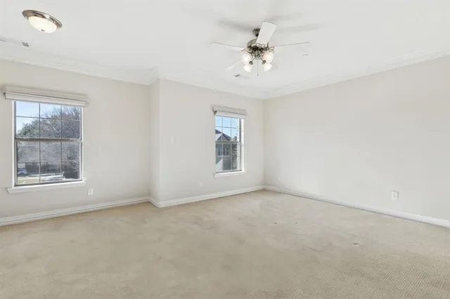 en empty room with windows and chandelier fan