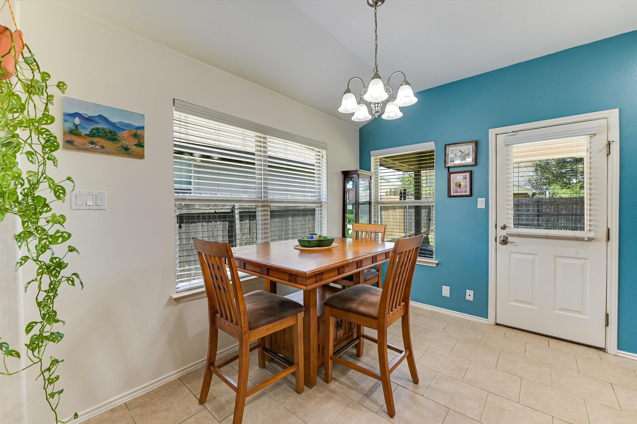 536 Dragon Ridge Road Buda, TX 78610 - Photo 6 of 20 Dining area featuring tile flooring, a multi-paneled glass door with blinds, and two windows with blinds