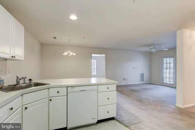 a kitchen with cabinets stainless steel appliances a sink and wooden floor