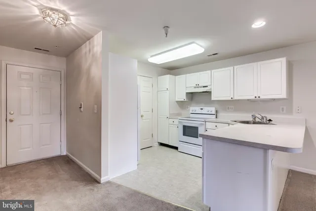 a kitchen with white cabinets and white appliances
