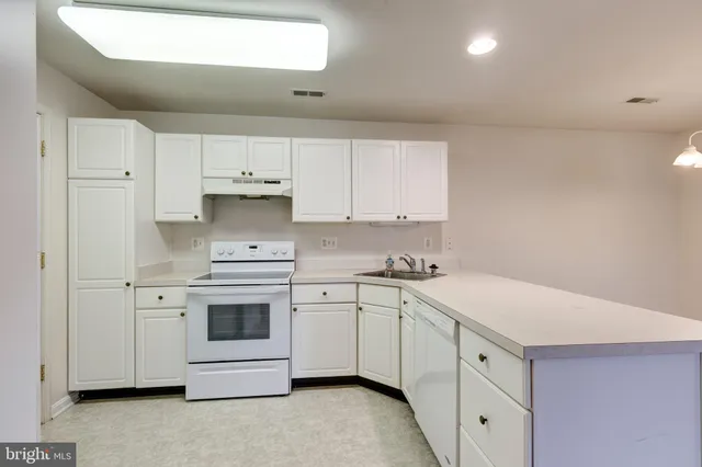 a kitchen with white cabinets stainless steel appliances and sink