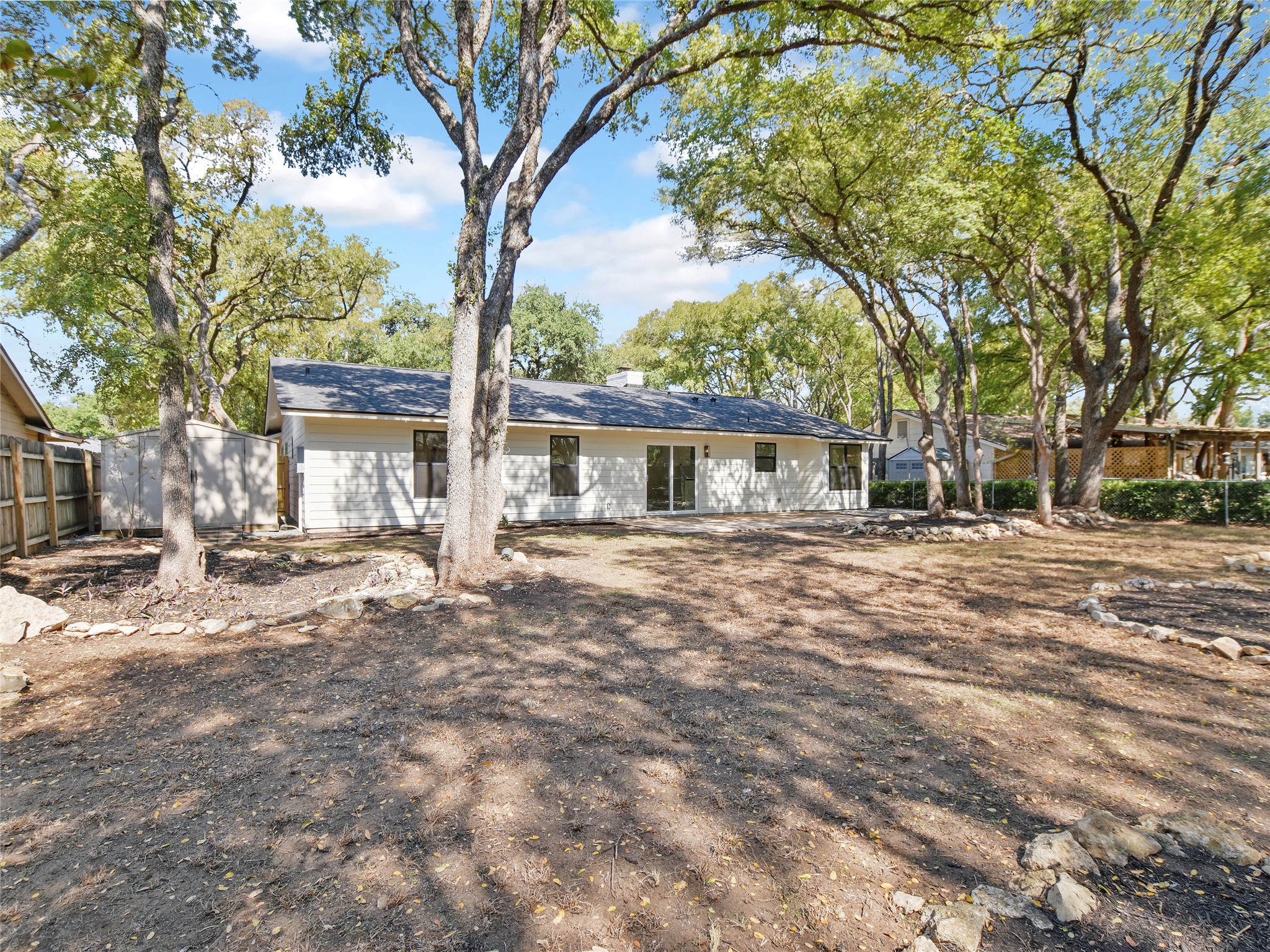 5903 Gateshead Drive Austin, TX 78745 - Photo 26 of 26 a backyard of a house with table and chairs under a large tree