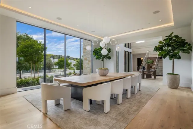 a dining hall with stainless steel appliances kitchen island a table and chairs in it
