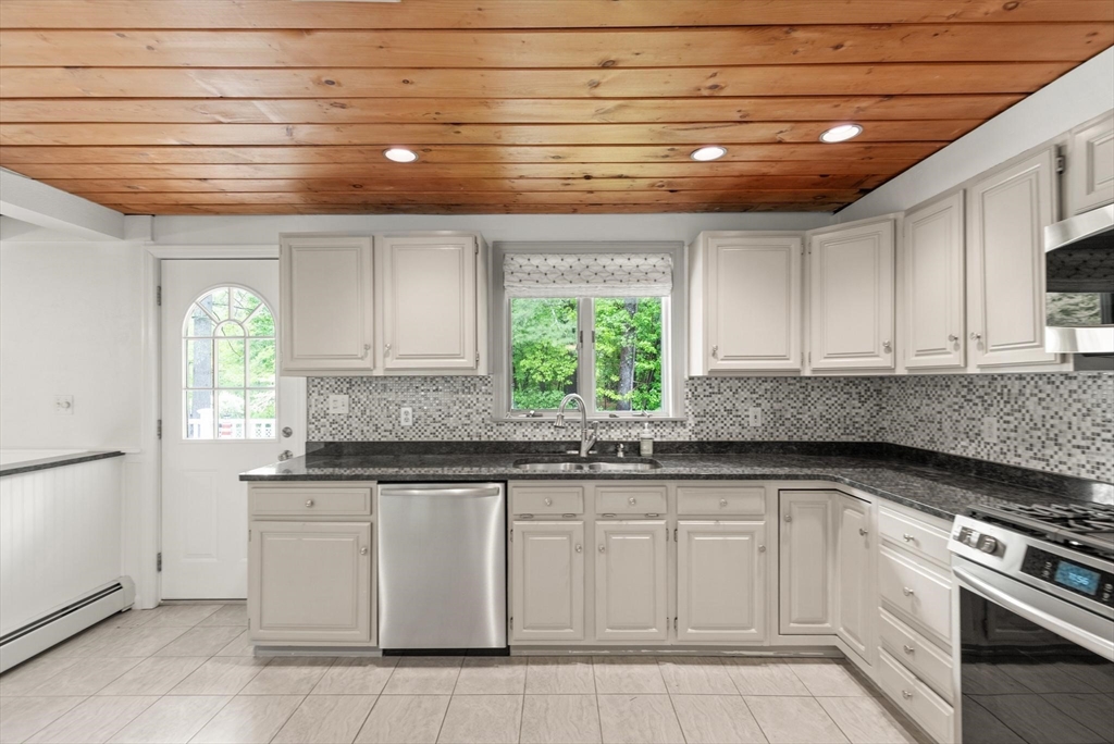 901 Haverhill Street Rowley, MA 01969 - Photo 9 of 42 a kitchen with white cabinets appliances a sink and a window