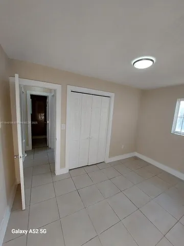 an empty room with a bathroom and a window