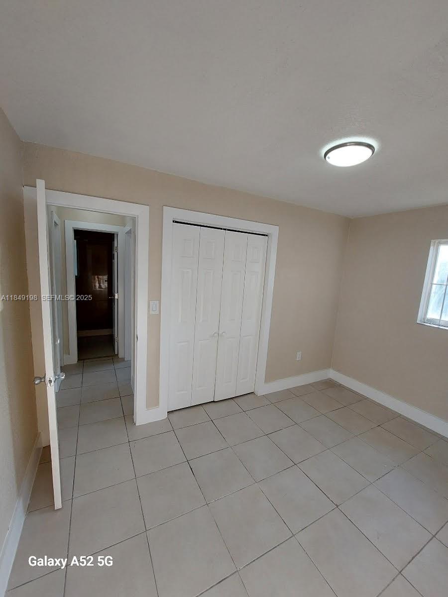 1574 Northwest 58th Street Miami, FL 33142 - Photo 11 of 11 an empty room with a bathroom and a window