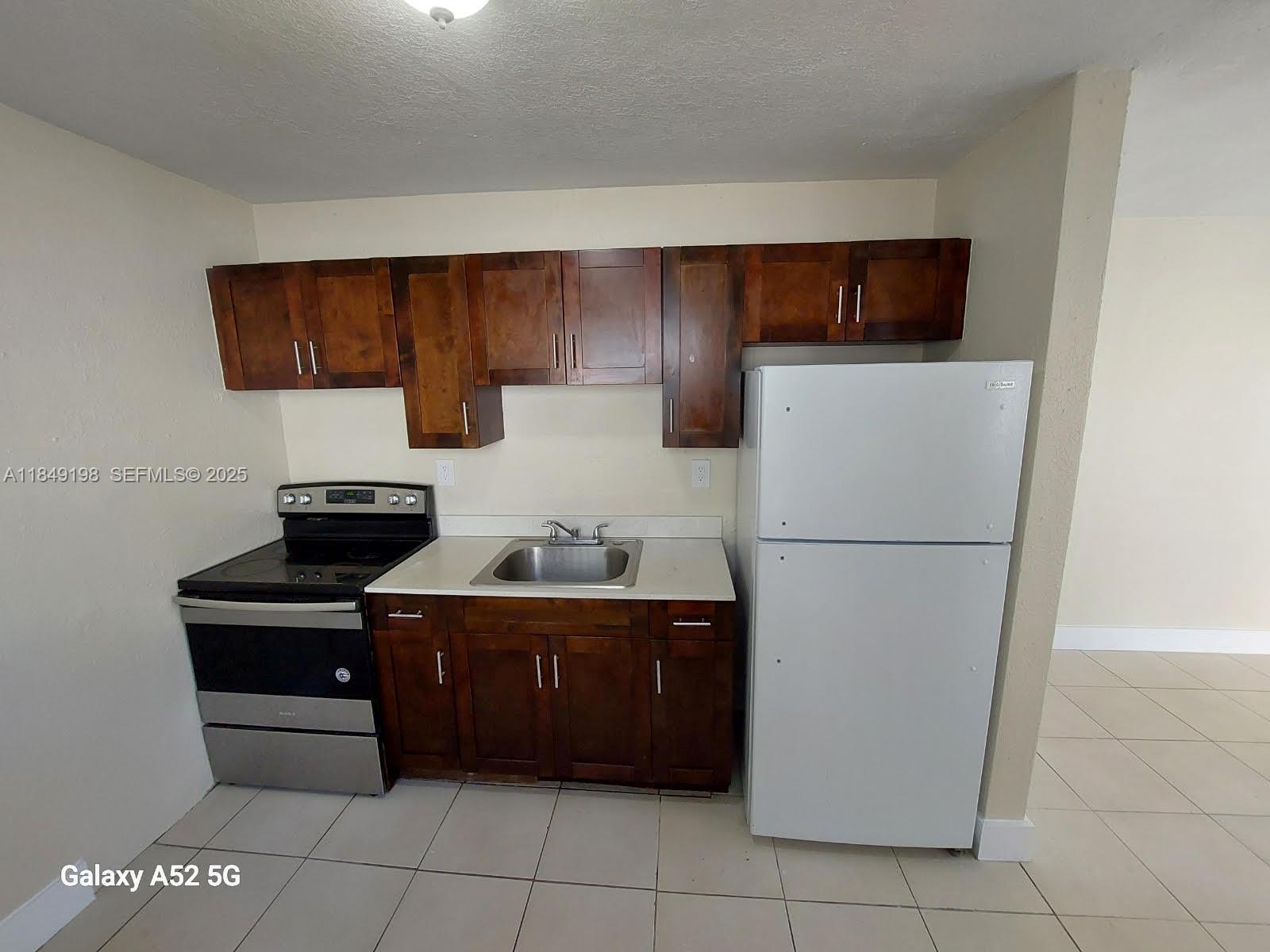 1574 Northwest 58th Street Miami, FL 33142 - Photo 3 of 11 a kitchen with a cabinets and appliances