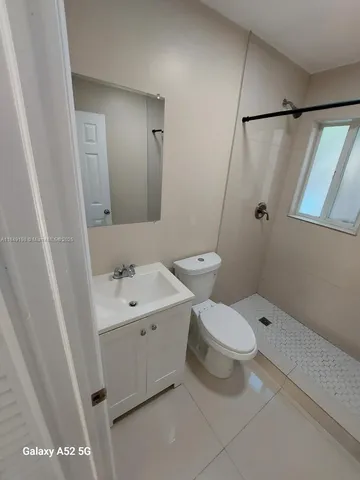 a bathroom with a white sink a toilet and shower