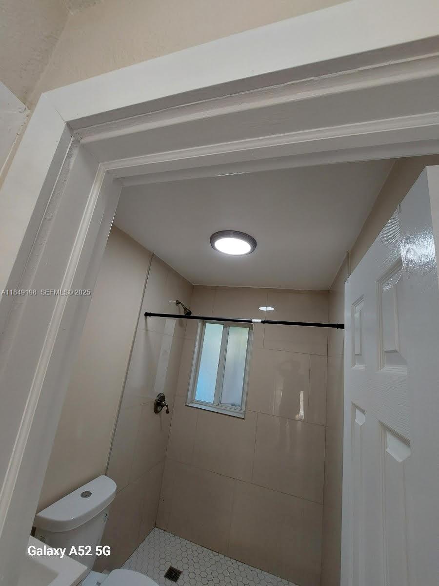 1574 Northwest 58th Street Miami, FL 33142 - Photo 8 of 11 a bathroom with a toilet and a shower