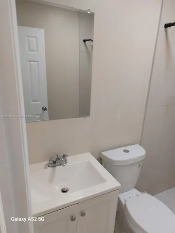 a bathroom with a sink a toilet and mirror