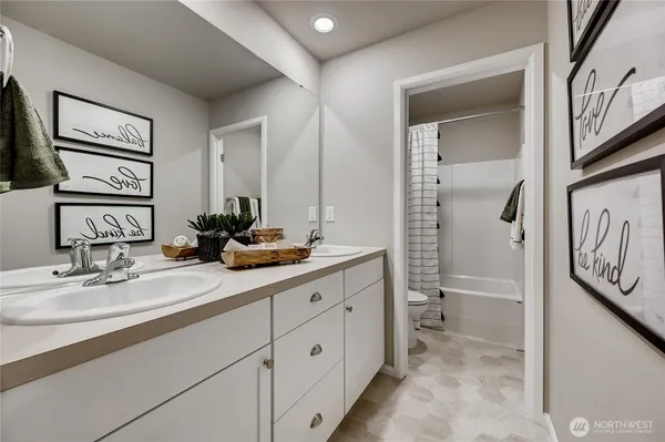 a bathroom with a double vanity sink a toilet and a mirror
