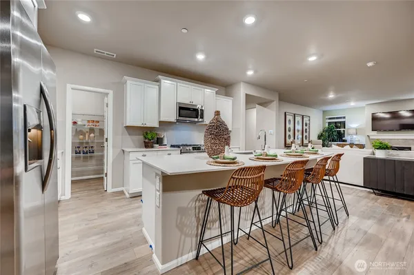 a kitchen with stainless steel appliances a stove a sink a refrigerator a center island and a refrigerator