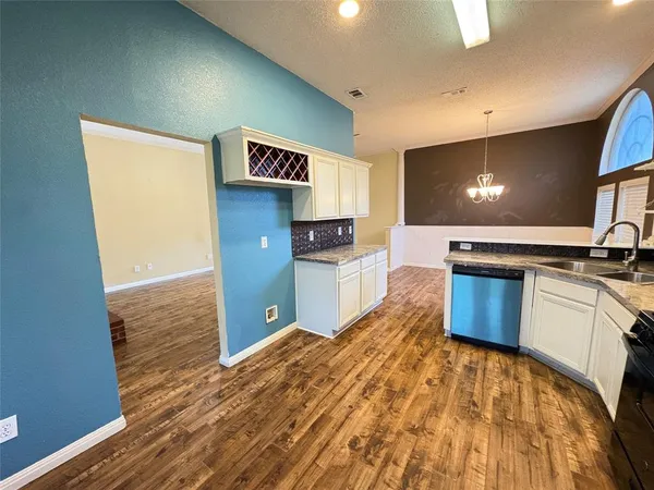 a kitchen with stainless steel appliances granite countertop a refrigerator a stove and a wooden floors