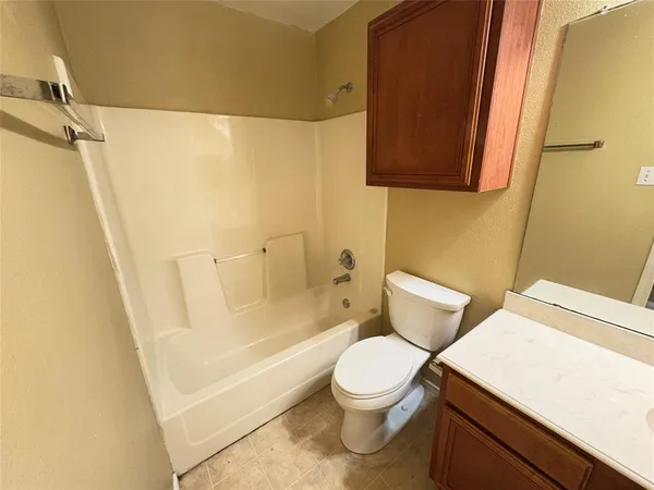 a white toilet sitting next to a bathroom sink and vanity