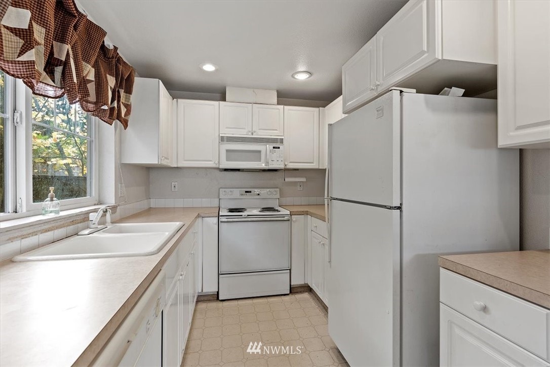 1160 Monroe Avenue Northeast, Unit B1 Renton, WA 98056 - Photo 17 of 24 a kitchen with stainless steel appliances a refrigerator sink and cabinets