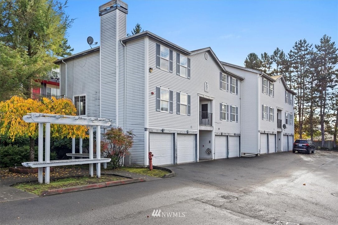 1160 Monroe Avenue Northeast, Unit B1 Renton, WA 98056 - Photo 4 of 24 a view of a white house with large windows and a table and chair