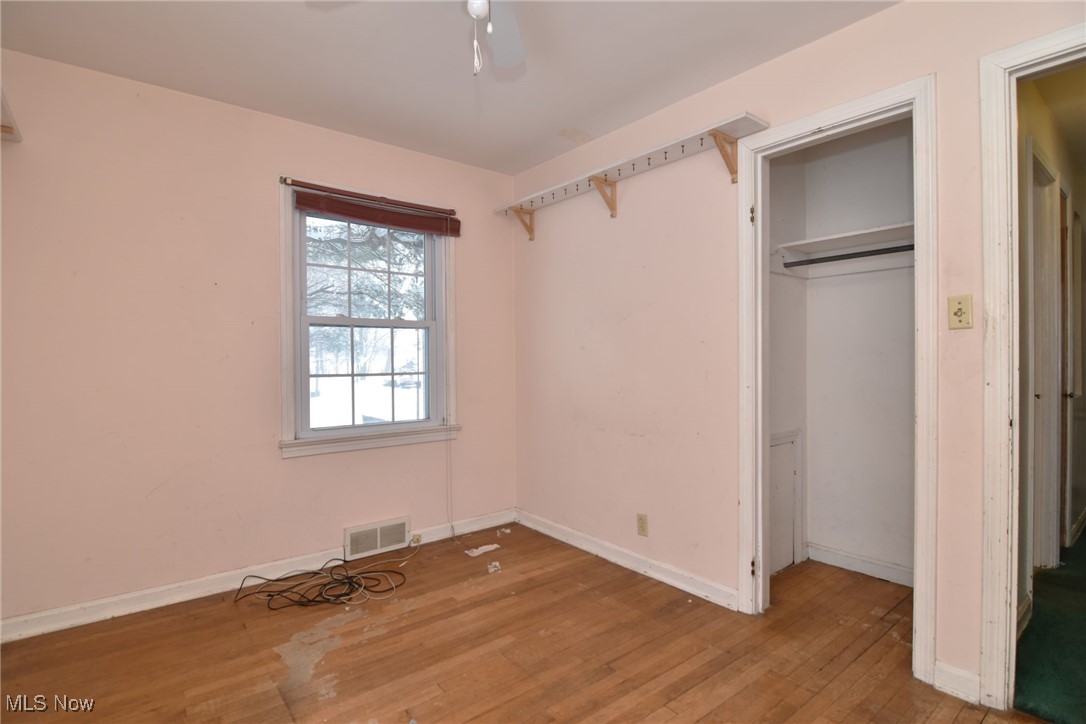 6308 Highland Road Cleveland, OH 44143 - Photo 26 of 40 Unfurnished bedroom with a closet, visible vents, hardwood / wood-style floors, a ceiling fan, and baseboards