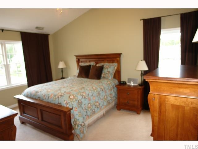 11901 Fairlie Place Raleigh, NC 27613 - Photo 7 of 12 a bed sitting in a bedroom next to a window
