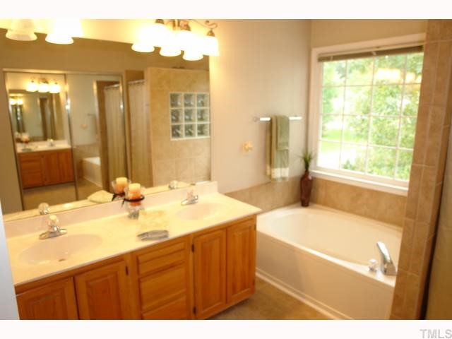 11901 Fairlie Place Raleigh, NC 27613 - Photo 8 of 12 a bathroom with a tub sink and mirror