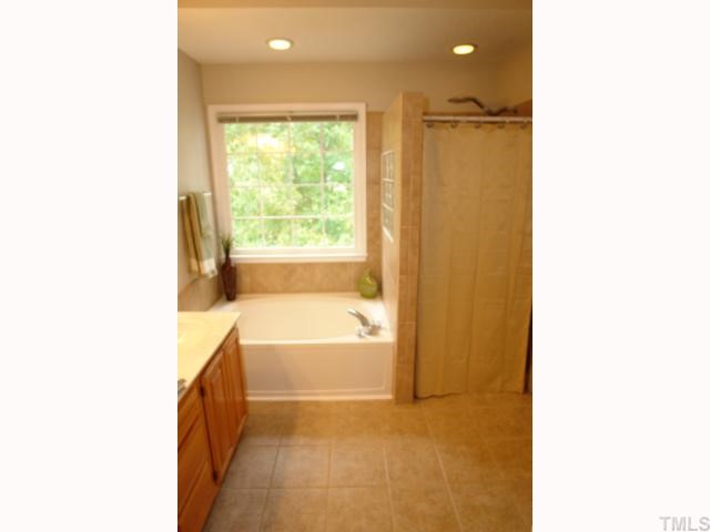 11901 Fairlie Place Raleigh, NC 27613 - Photo 9 of 12 a bathroom with a tub shower and a sink
