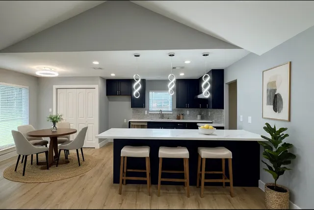 a large kitchen with stainless steel appliances kitchen island granite countertop a stove a sink and a refrigerator