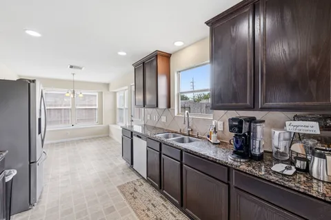 a kitchen with stainless steel appliances granite countertop a refrigerator and a sink