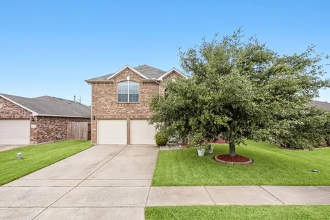 a front view of a house with a yard and trees