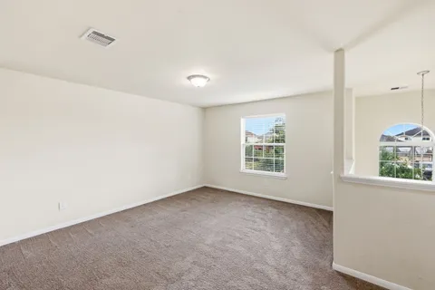 an empty room with a window and a fan