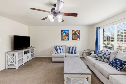 a living room with furniture and a chandelier