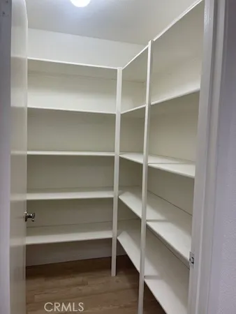 a view of walk in closet with empty racks
